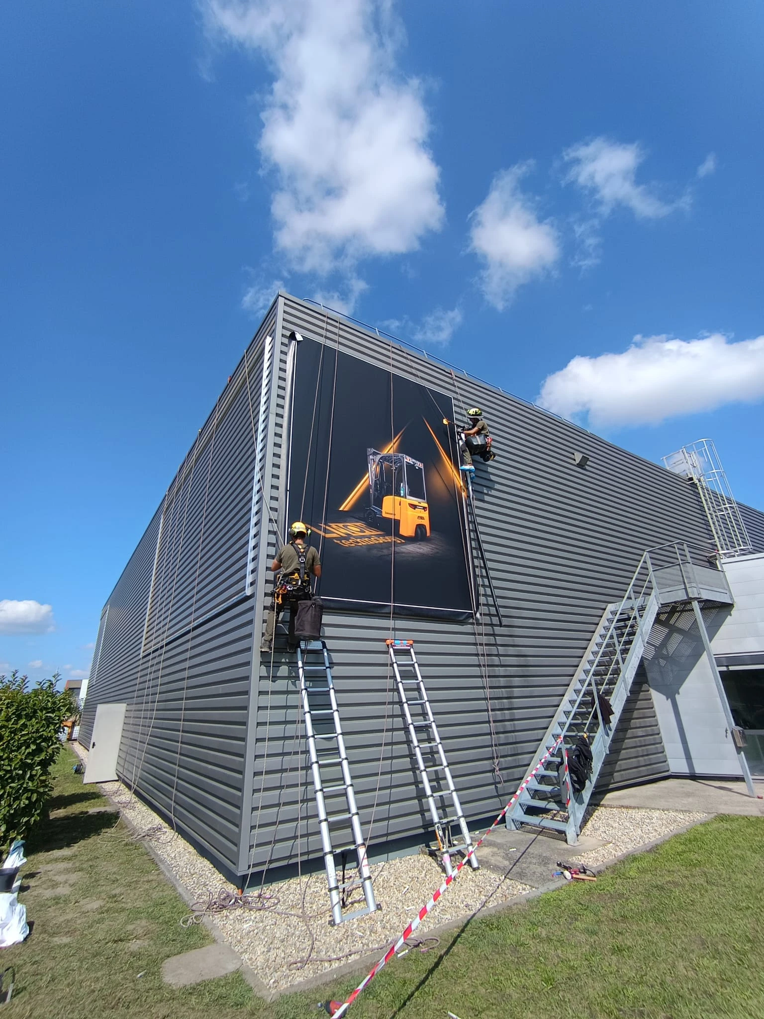 Remplacement de bâches publicitaires en façade industrielle